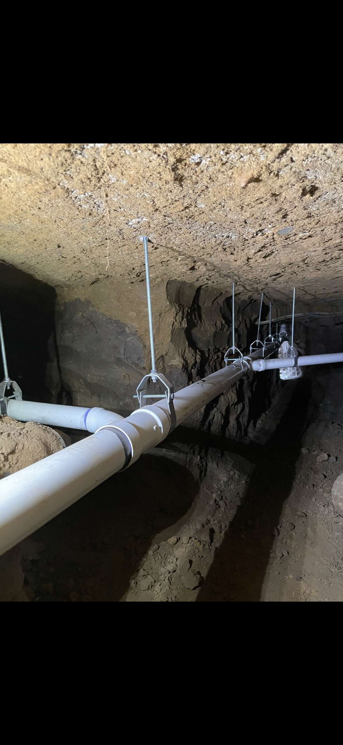 Rerouted plumbing lines installed below a home by Flow Bros Plumbing