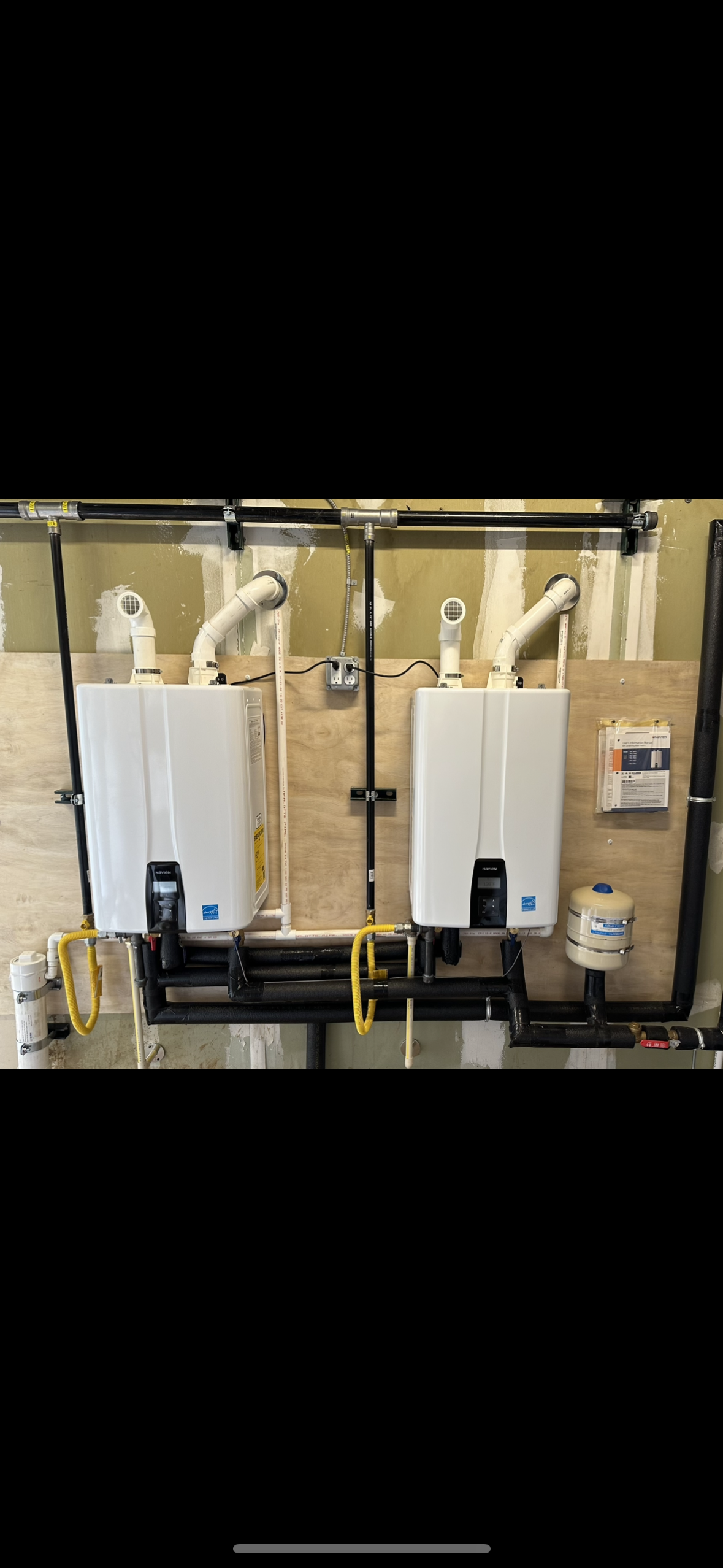Dual tankless water heater installation with professional gas, venting and water connections